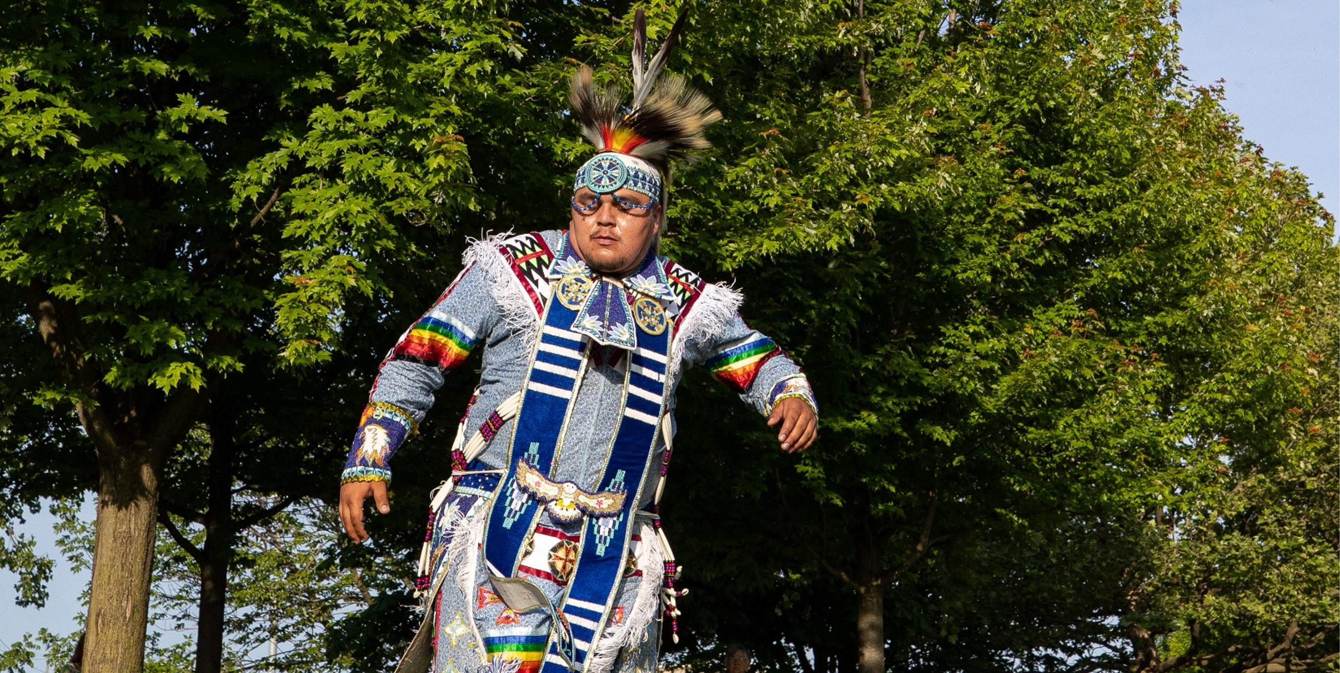Indigenous man in traditional garment dancing