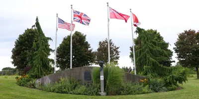 Camp X Memorial with flags and metal bust 