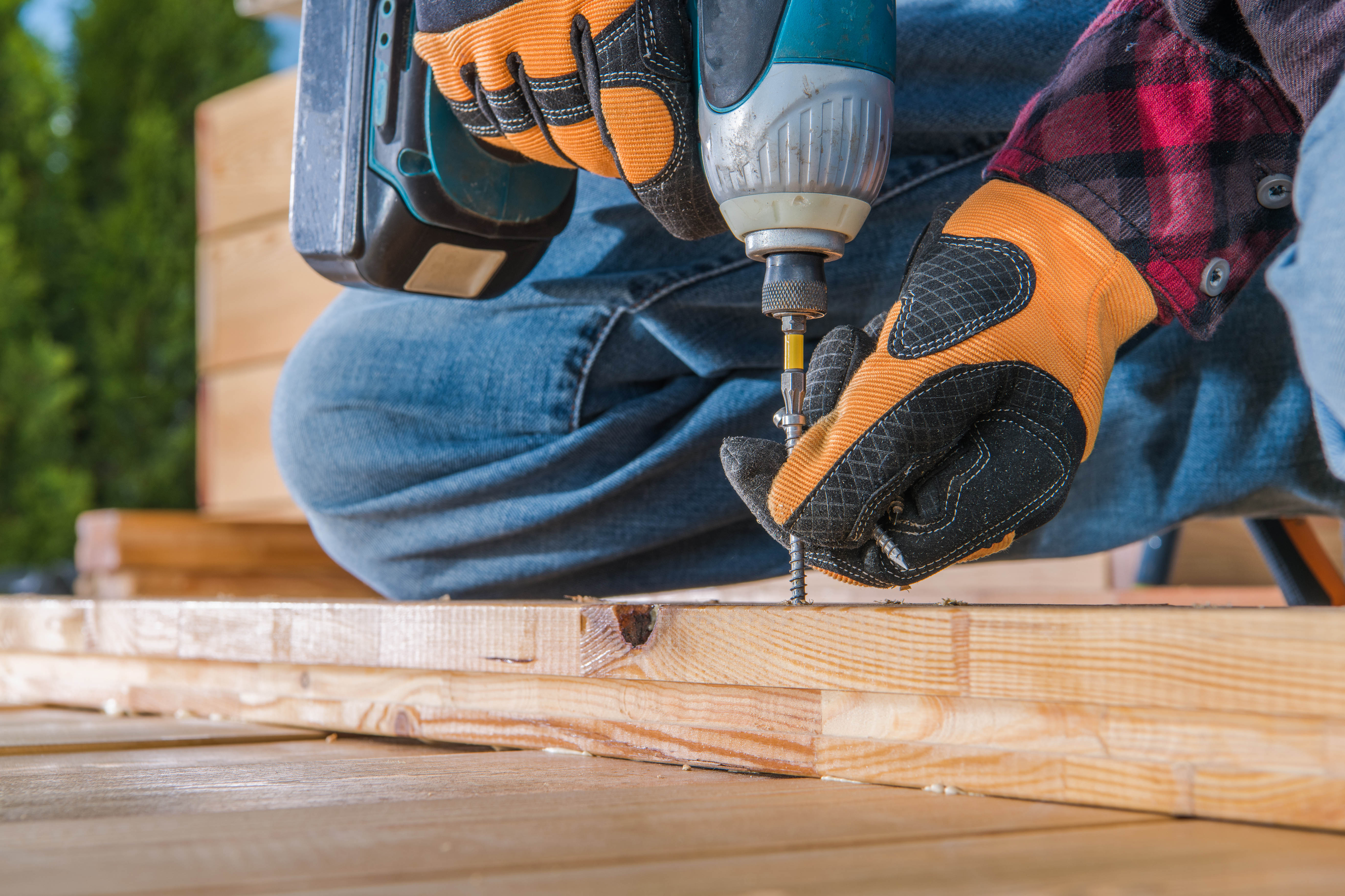 Person drilling screw into wood boards
