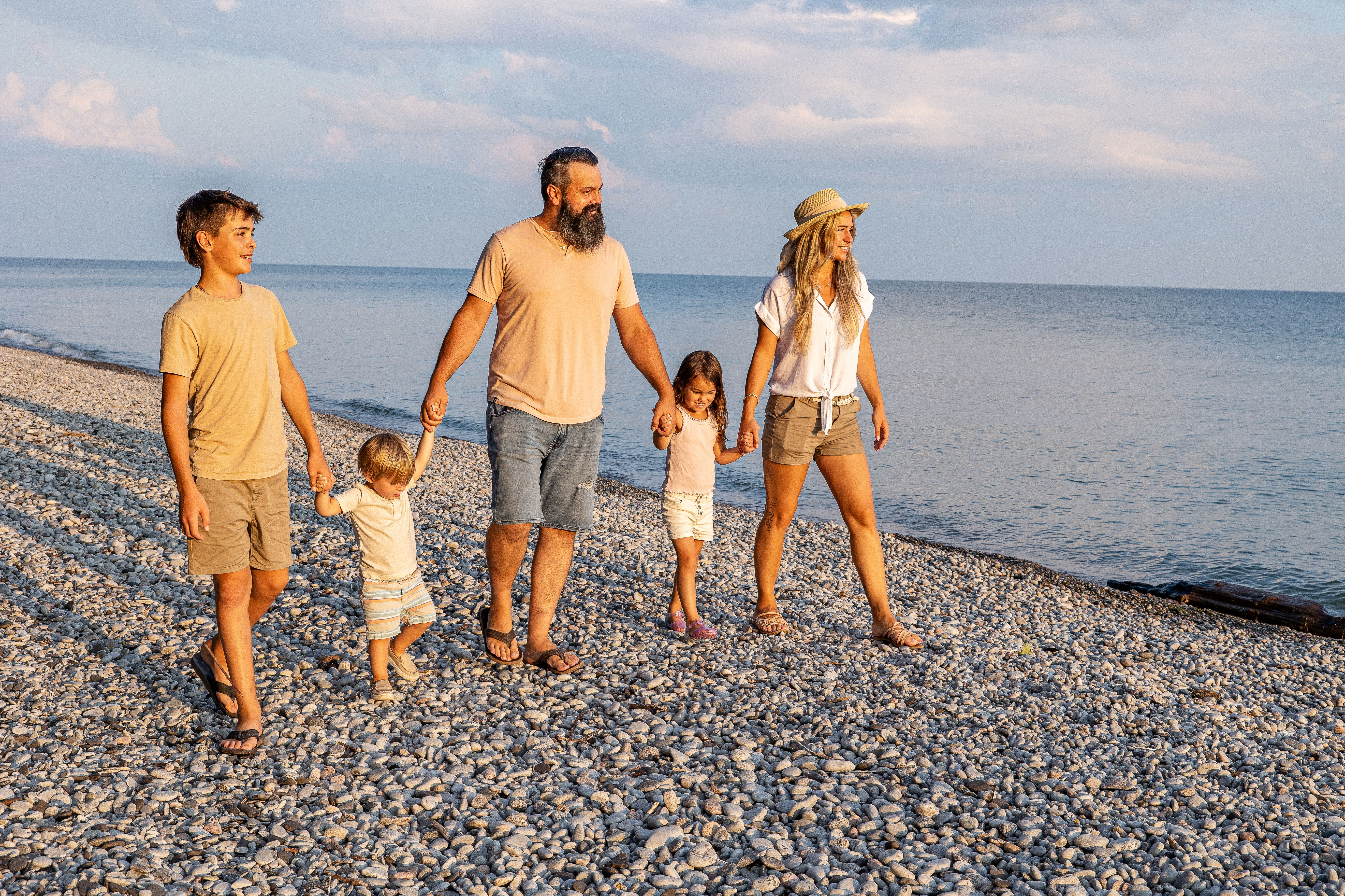 Family holding hand strolling waterfront