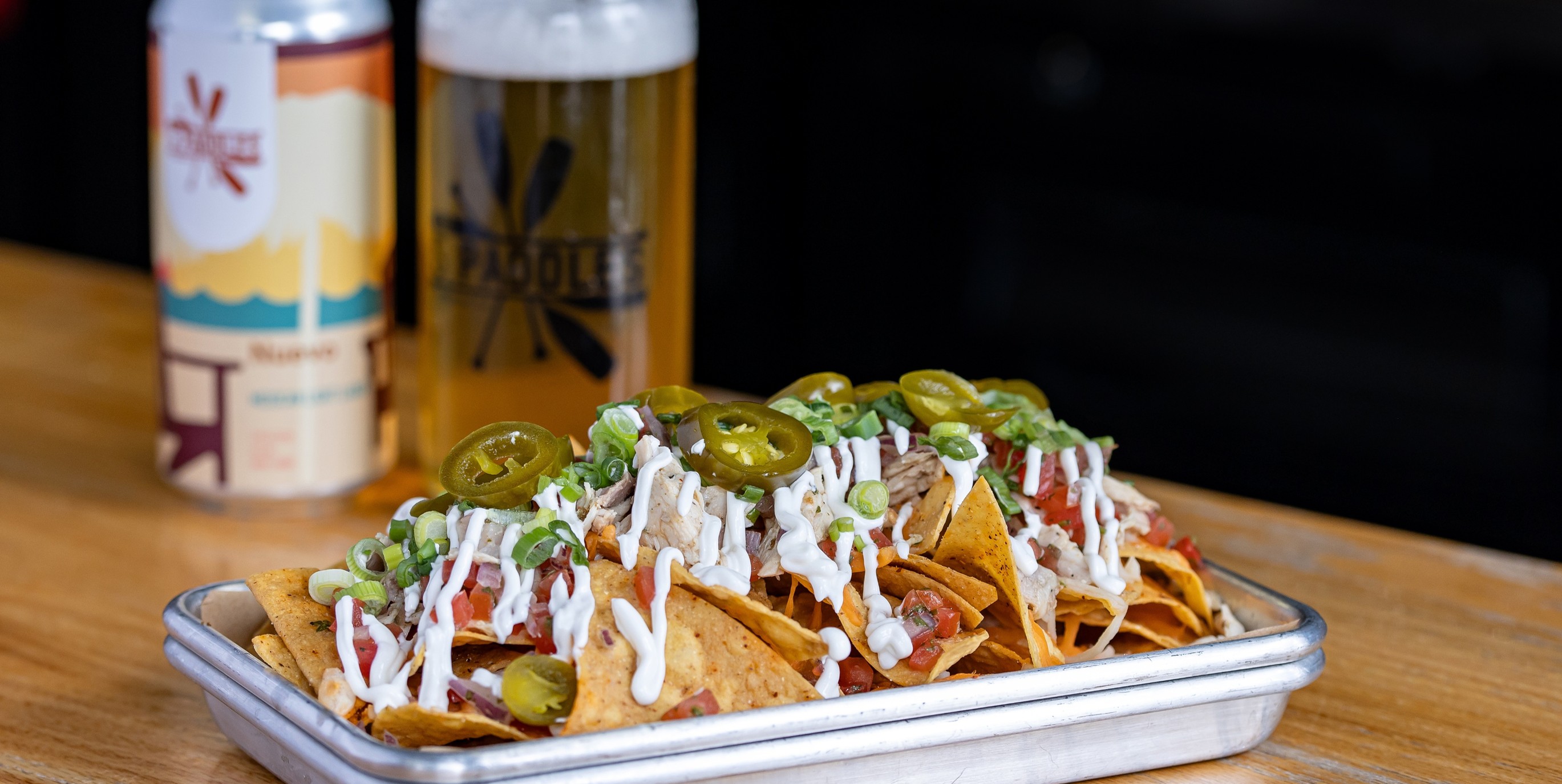 Close of of nachos and with beer in back