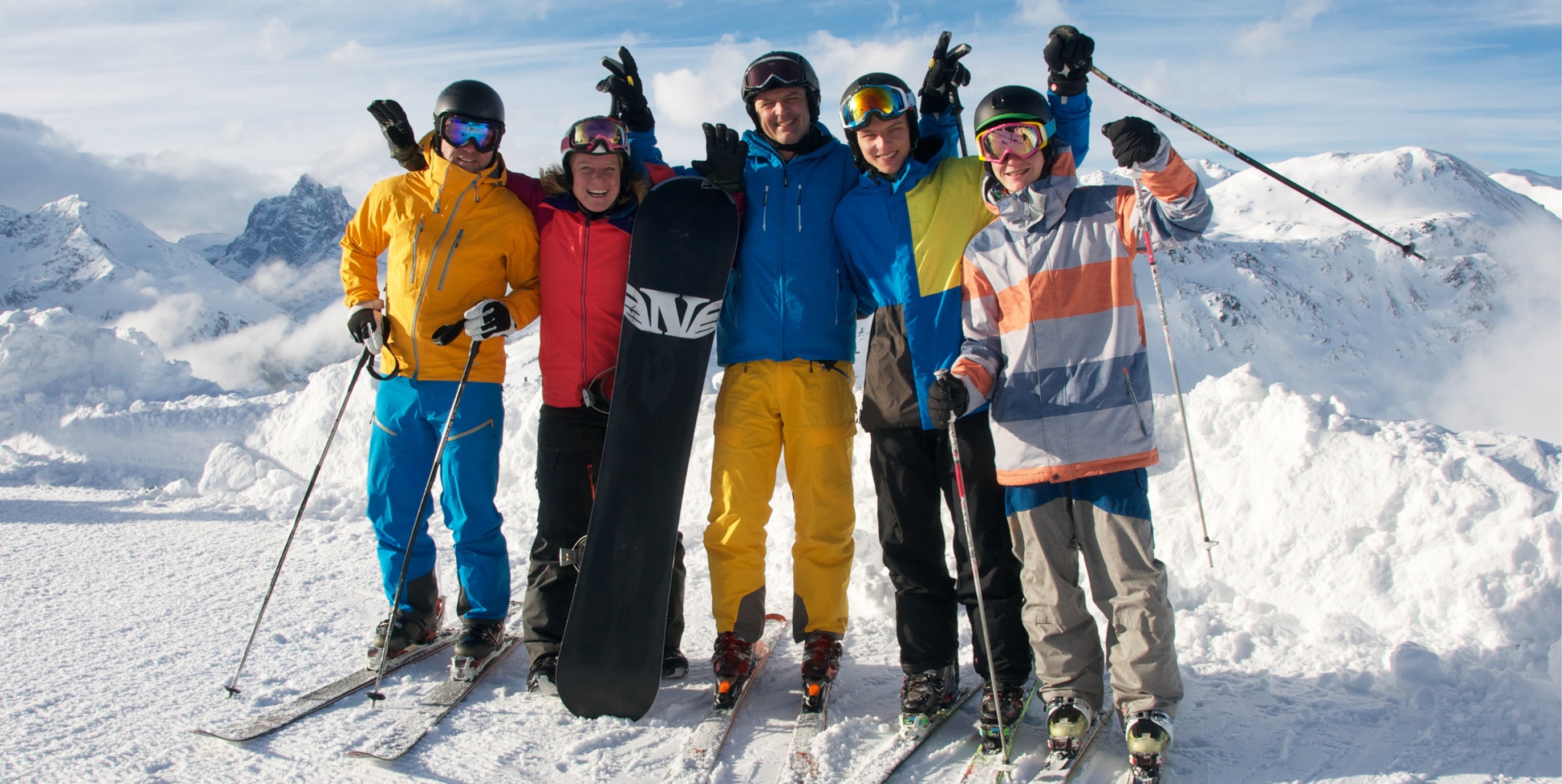 Family on top of a ski hill smiling